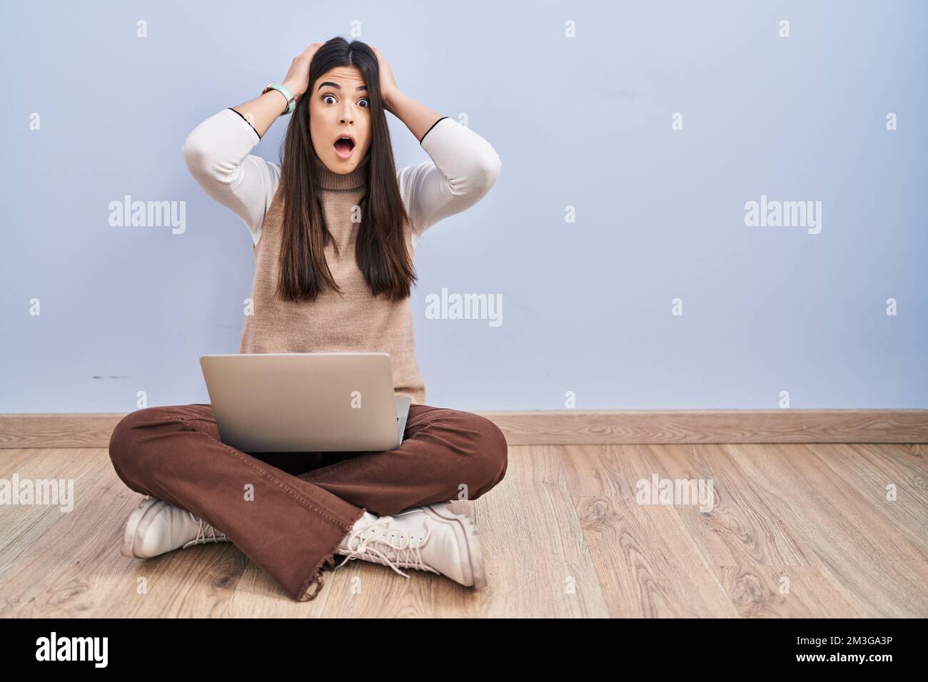 Young brunette woman working using computer laptop sitting on the floor ...