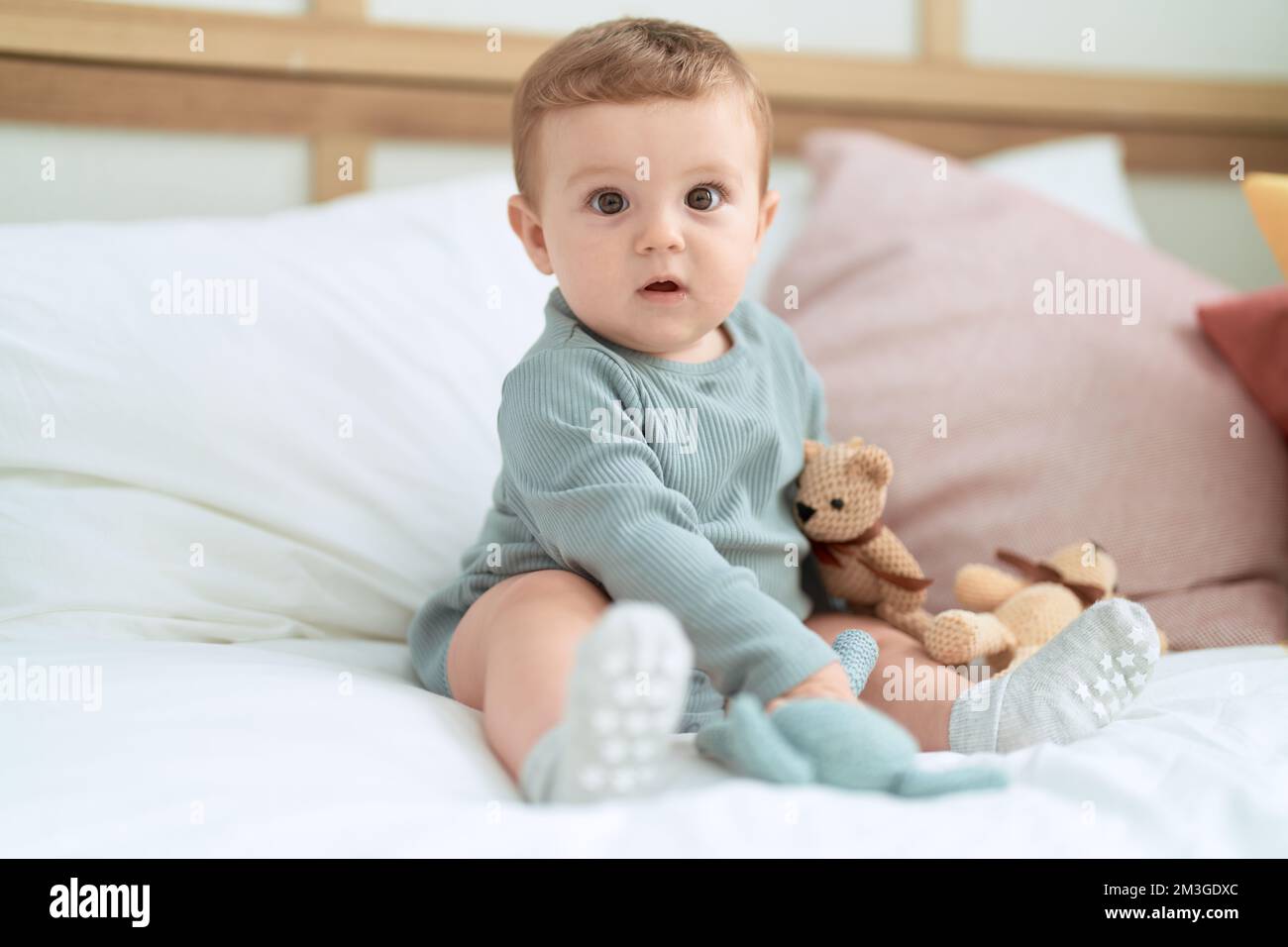 Adorable toddler sitting on bed with dolls at bedroom Stock Photo - Alamy