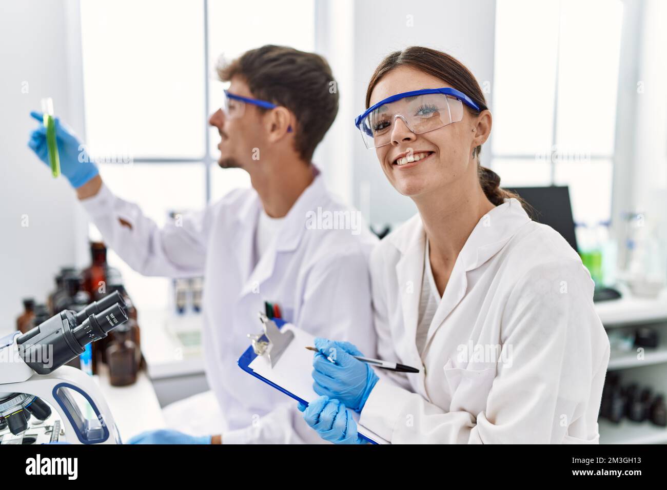 Man and woman partners wearing scientist uniform working at laboratory ...