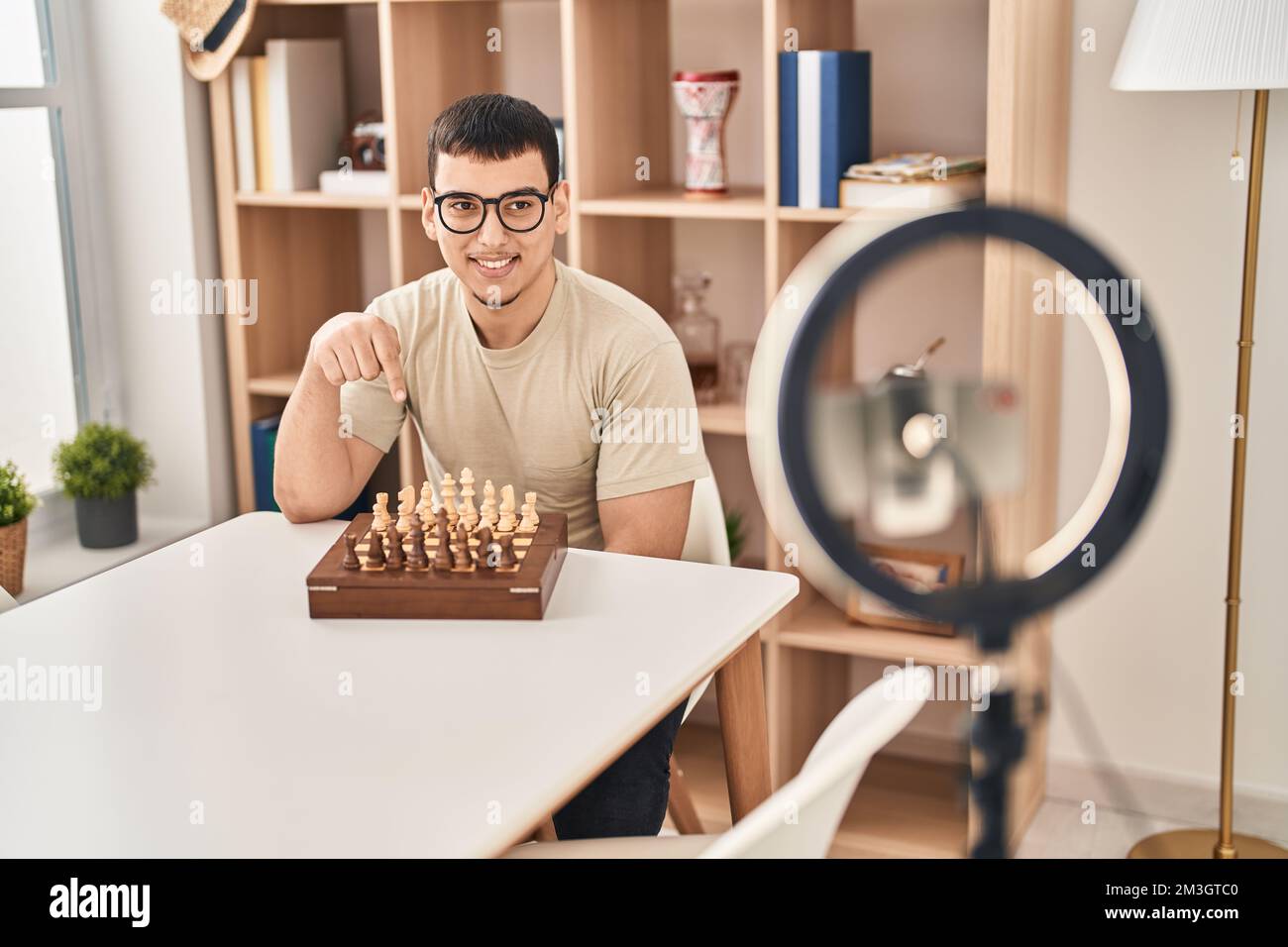Young arab man doing chess tutorial smiling happy pointing with hand and finger Stock Photo