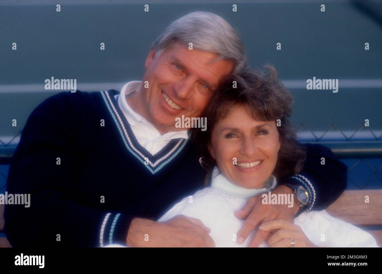 Older couple embracing while posing to look at the camera Stock Photo