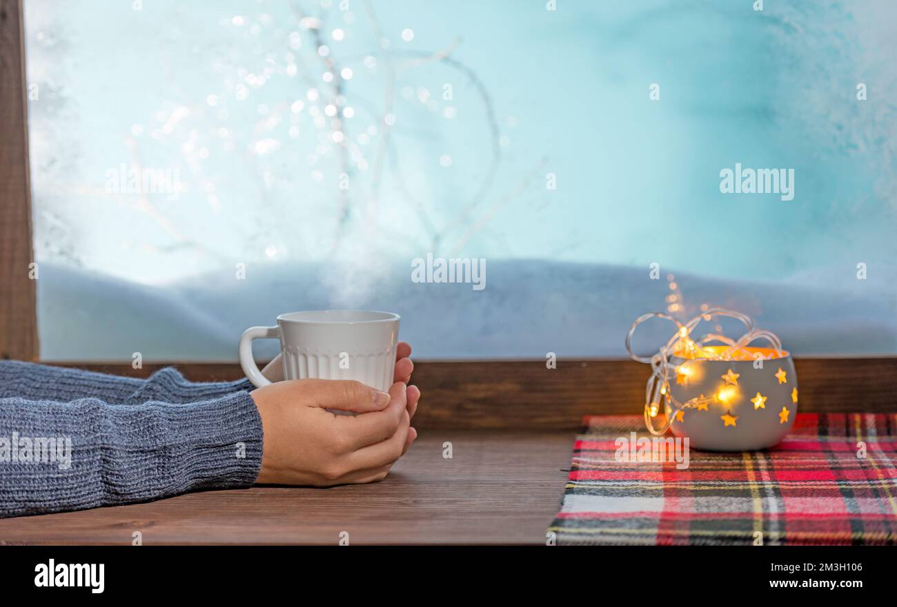 cozy winter window sill with cup of tea and warm blanket Stock Photo