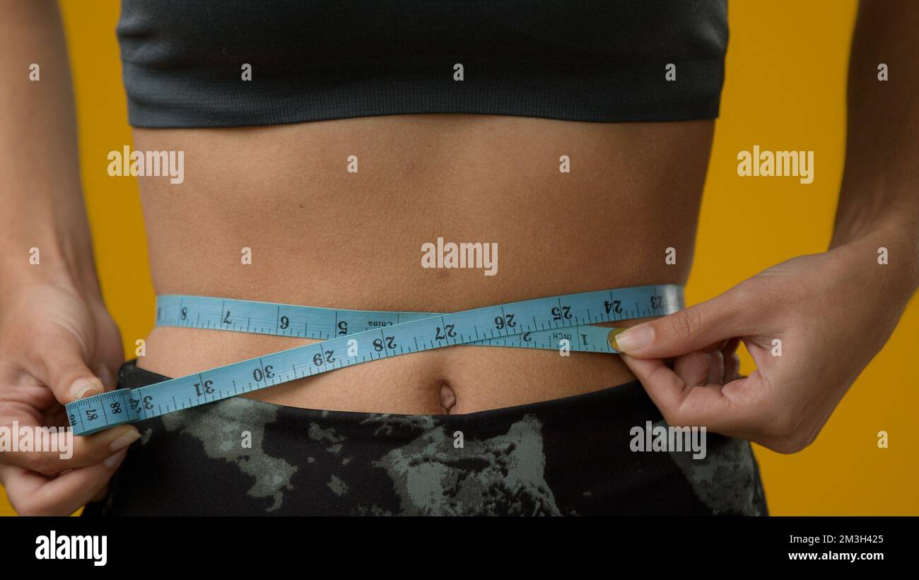 Woman Measuring Waist Using Tape Measure Mid Section High-Res Stock Photo -  Getty Images