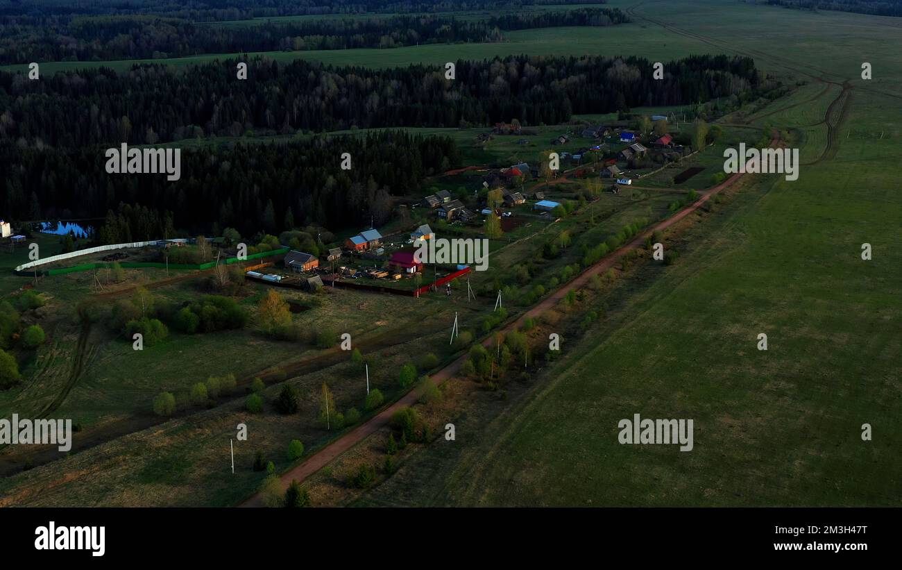 Summer view of a small provincial town from a helicopter. Clip.A green city in the middle of forests with large fir trees where there is a church and Stock Photo