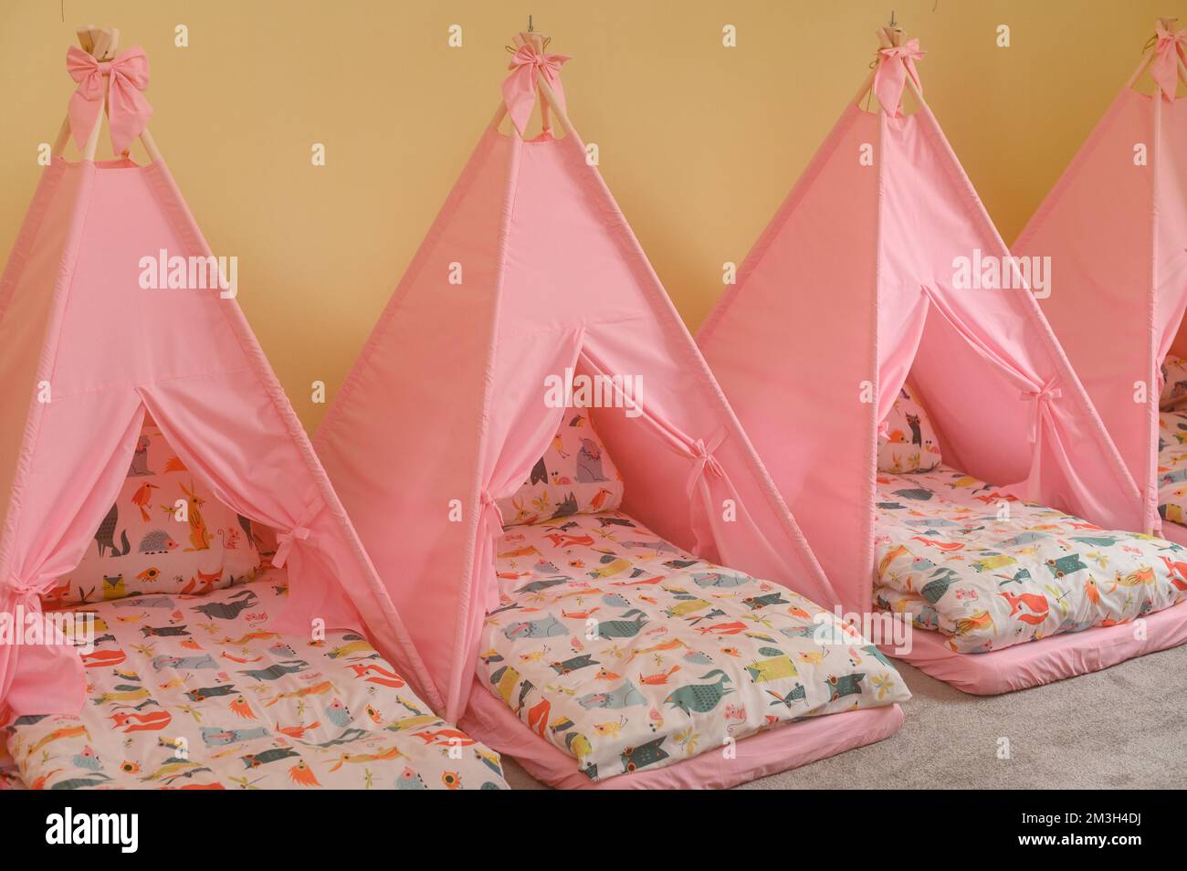 Baby cots in the kindergarten for naps in the form of tents, bright