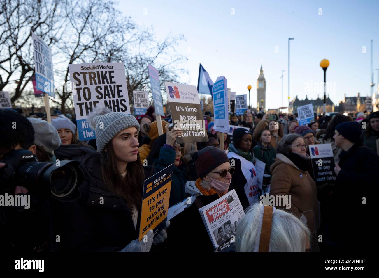 Nurses and other healthcare professionals hold placards expressing ...