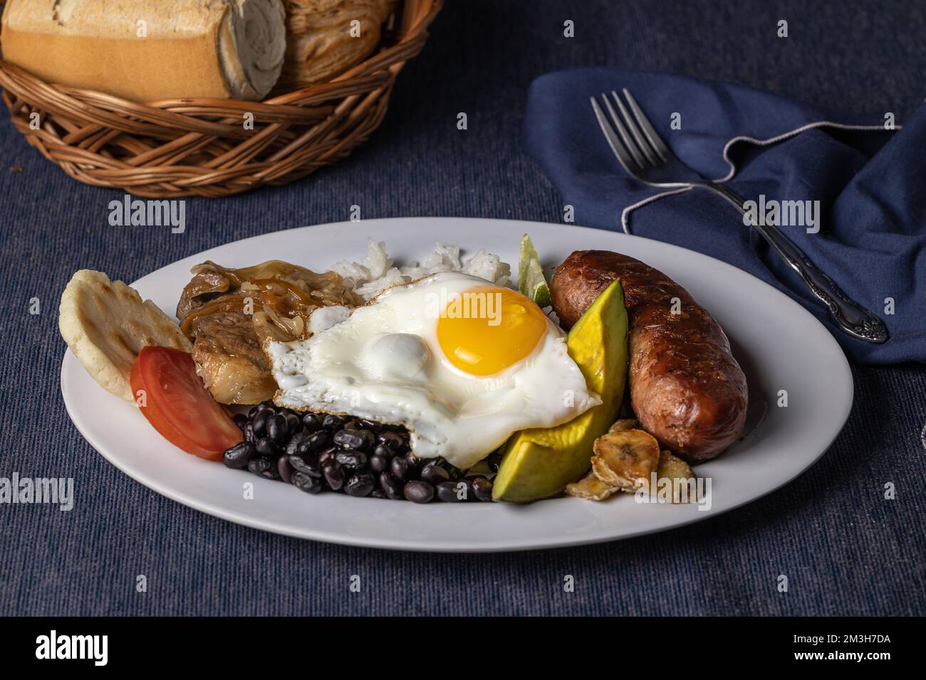 Bandeja paisa, typical food of Colombia on blue tablecloth. Stock Photo