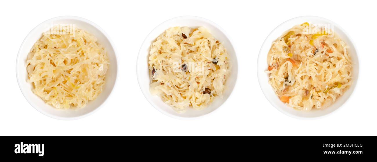 Sauerkraut variants, fermented cabbage in white bowls. In Germany and Austria a warm served side dish. Stock Photo