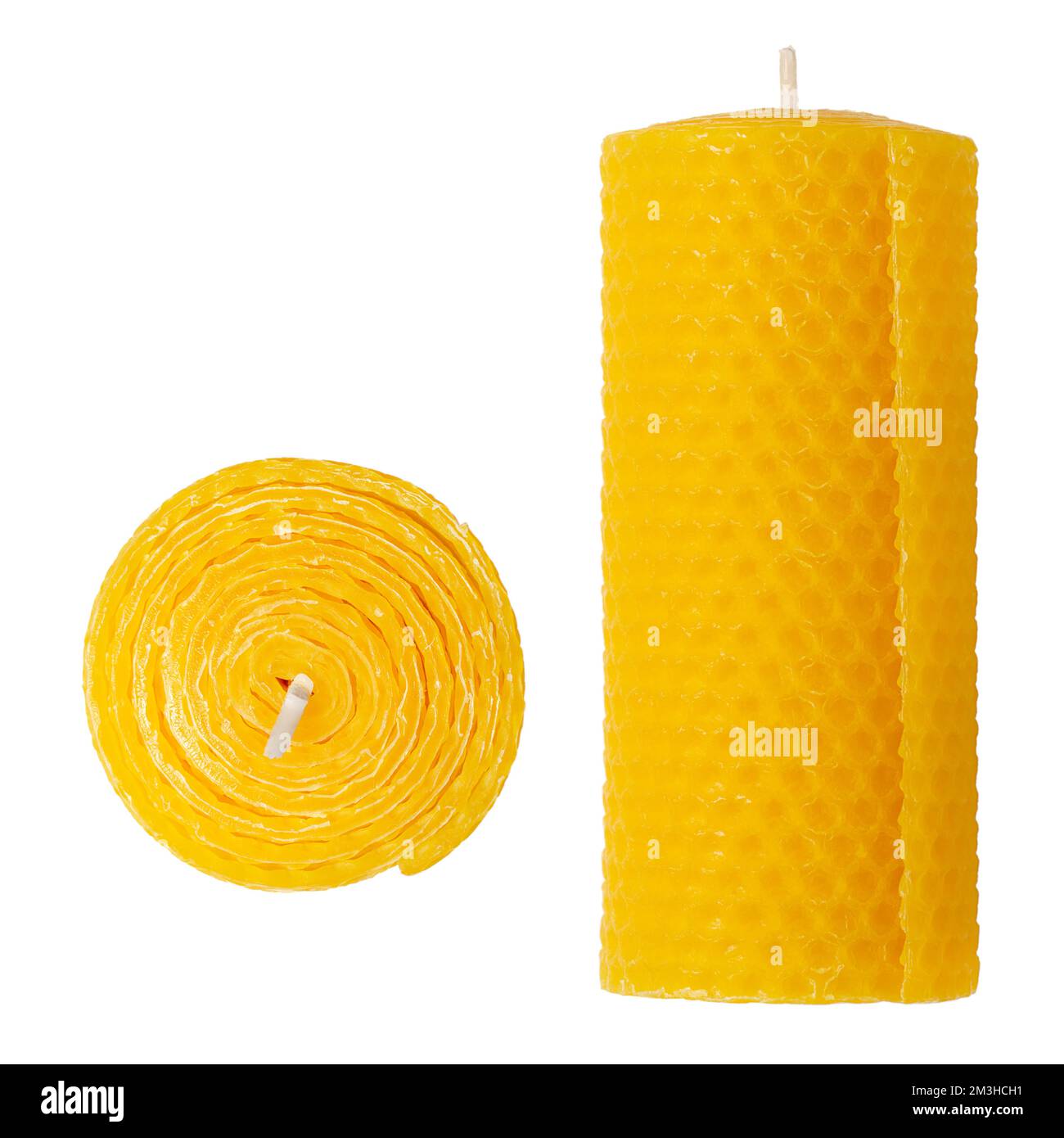 Beeswax pillar candle, isolated from above and front view. Made by pressing natural bees wax between metal rollers, for the typical honeycomb pattern. Stock Photo