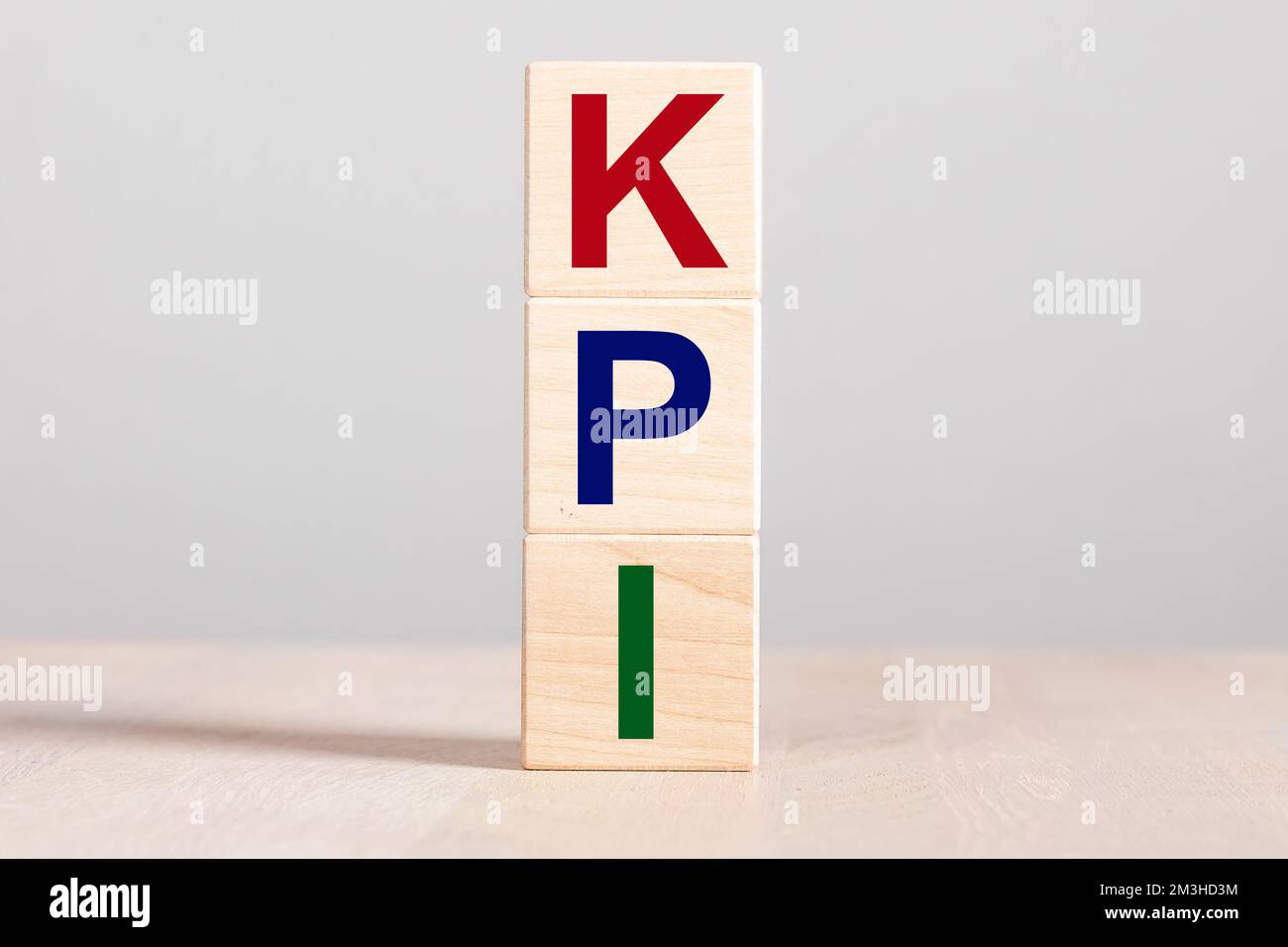 KPI acronym for Key Performance Indicator, letters on cube blocks on wood desk. High quality