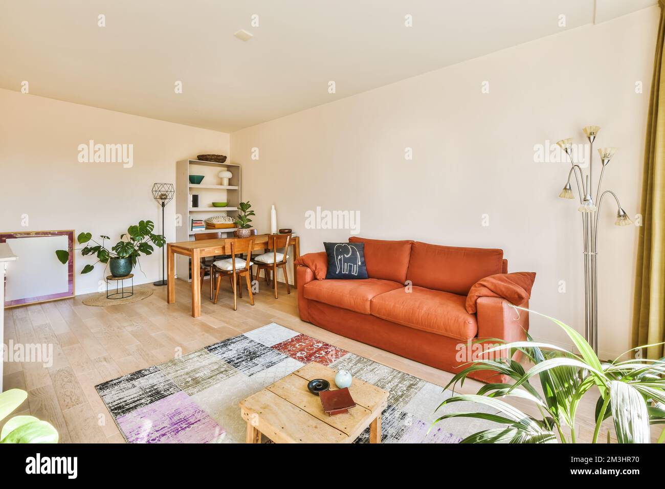 a living room with an orange couch and wooden coffee table in the room ...