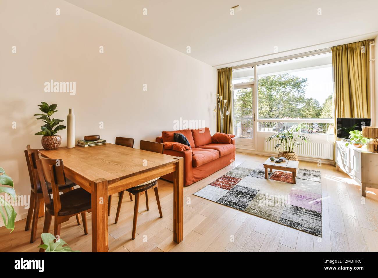 a living room with a table and chairs in front of the window looking ...