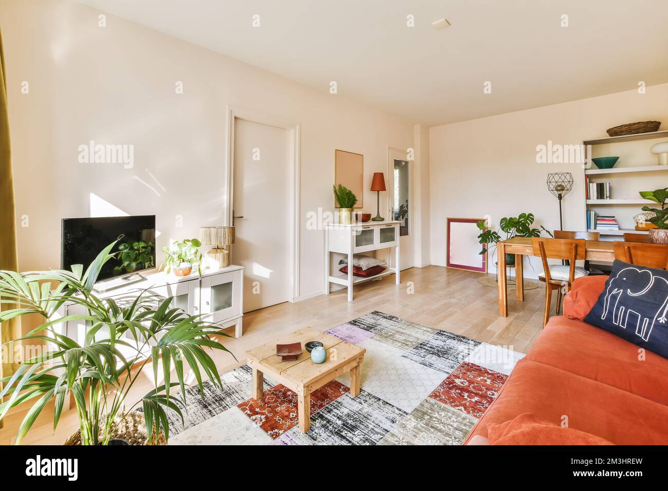 a living room with an orange couch and wooden coffee table in the room ...