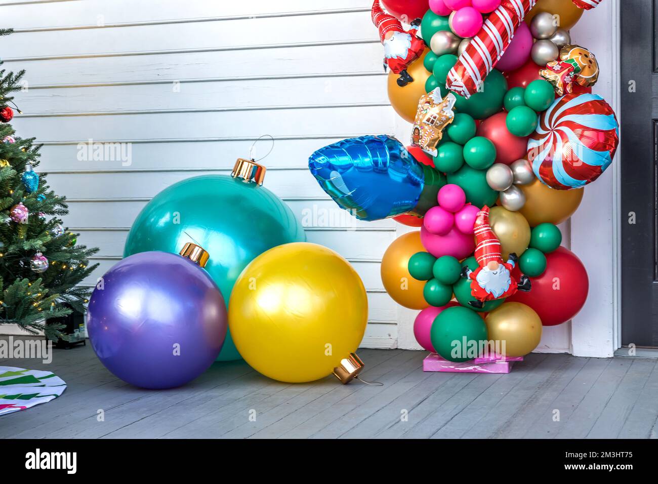 https://c8.alamy.com/comp/2M3HT75/a-white-siding-building-exterior-with-balloons-and-large-ornamentsfor-a-festive-christmas-decoration-or-decor-2M3HT75.jpg