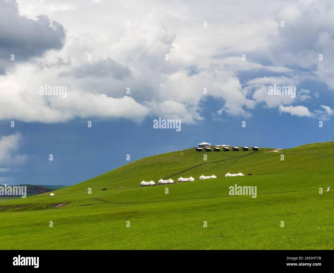 The Yurts (Gears) in a wide mountain grassland under blue cloudy sky in inner Mongolia, China Stock Photo