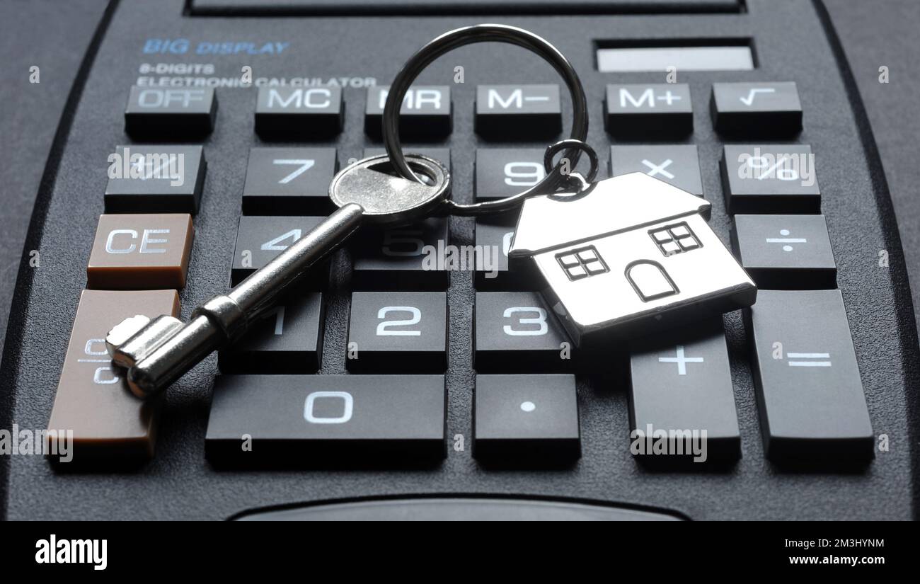 HOUSE KEY AND KEY RING WITH CALCULATOR RE MORTGAGE PAYMENTS HOUSING MARKET COST OF LIVING CRISIS ETC UK Stock Photo