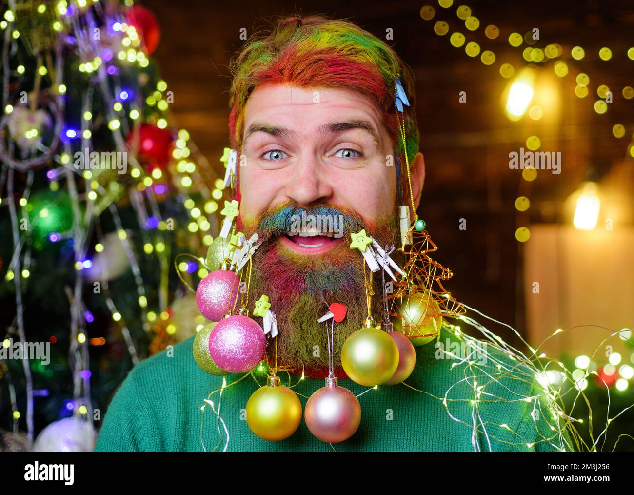 Happy bearded man with decorated beard. New year party. Christmas decorations. Winter holidays. Stock Photo