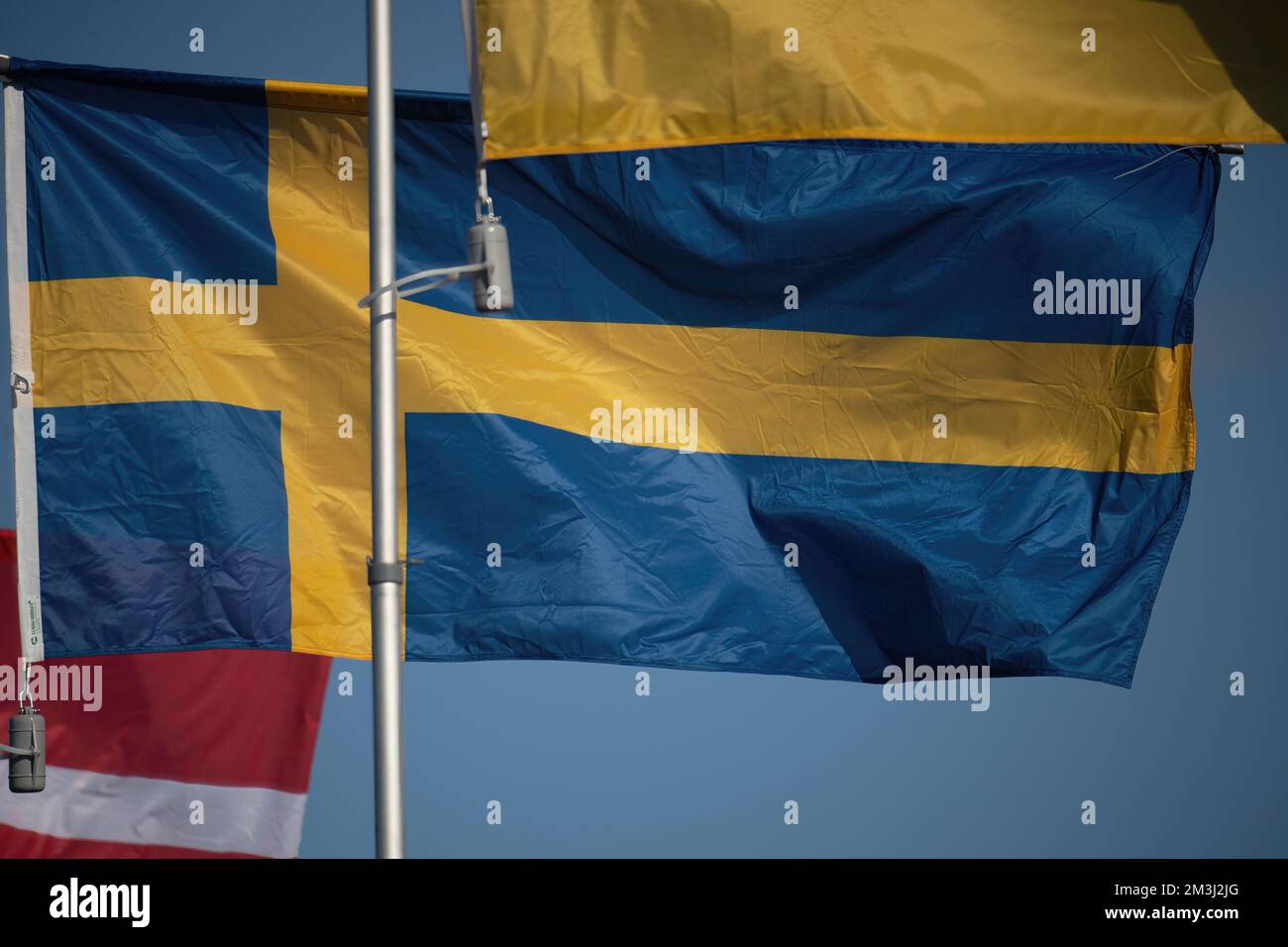 Flag of Sweden on flagpole waving in the wind on a beautiful sunny day with blue sky Stock Photo
