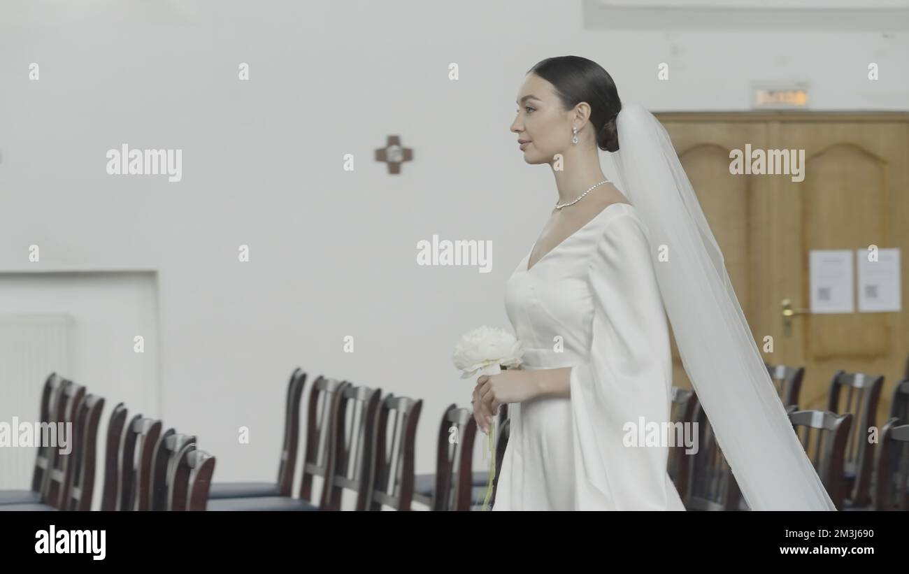 Beautiful bride walks down aisle. Action. Bride walks alone to altar in