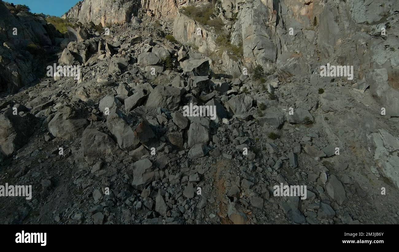 Aerial view of a stone mountain slope. Shot. Rock cliff with stones on a sunny day Stock Photo