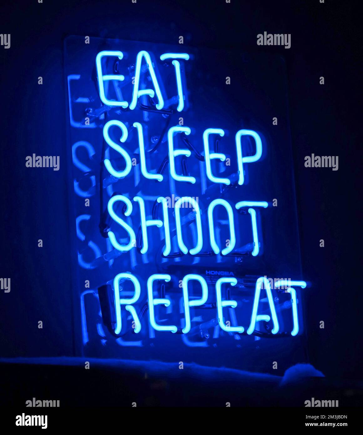 Blue neon sign, Eat, Sleep, Shoot, Repeat Stock Photo