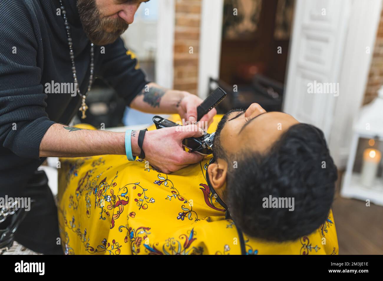man getting a beard haircut by a barber at barbershop, man self-care concept. High quality photo Stock Photo
