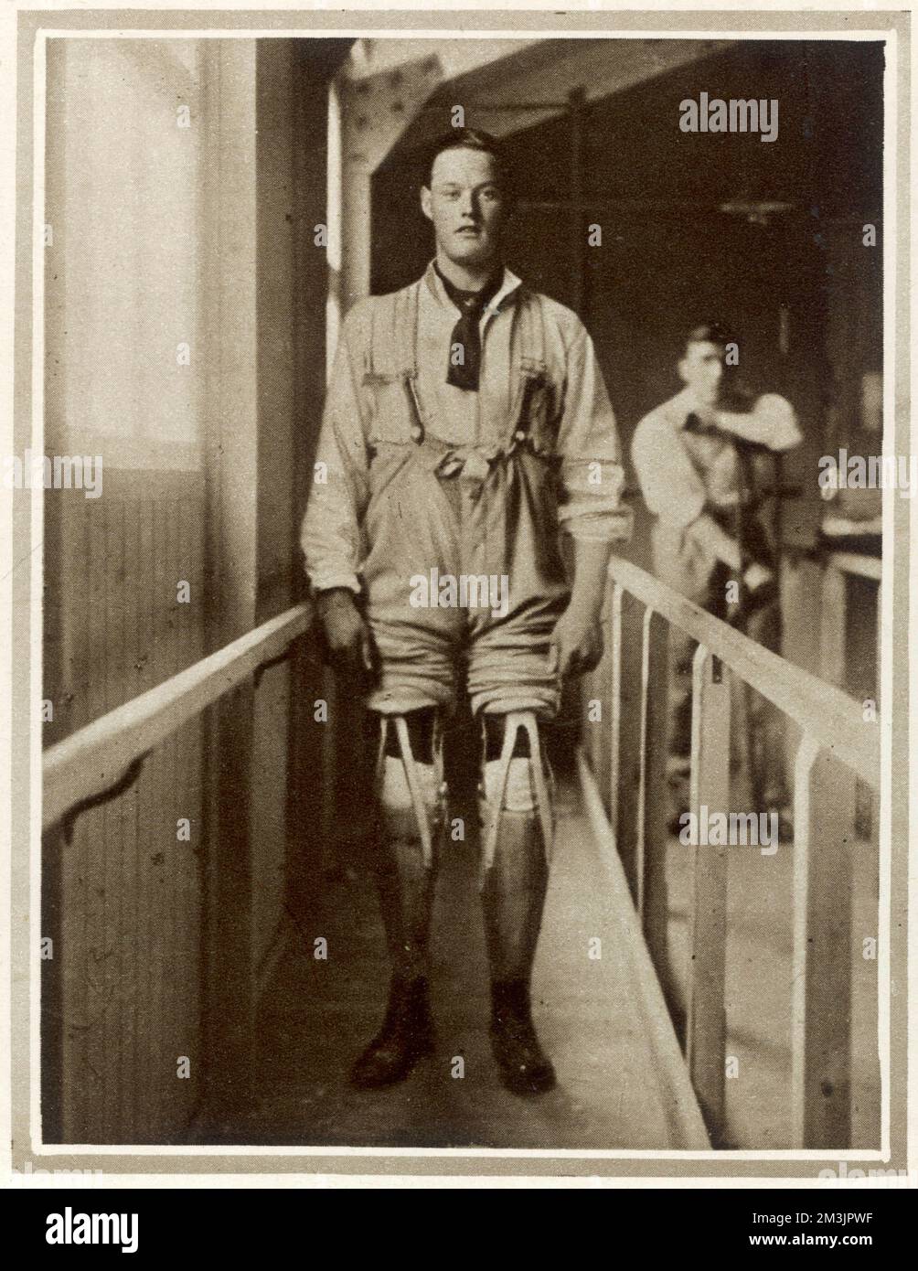 A wounded British soldier making his first attempt to walk with artificial legs. The photograph was taken at Queen Mary's Convalescent Auxiliary Hospital at Roehampton House. The hospital specialised in fitting artificial limbs under skilled advice and taught men how to use them. It was estimated that around 250,000 British soldiers lost limbs during World War I and one million worldwide. Stock Photo