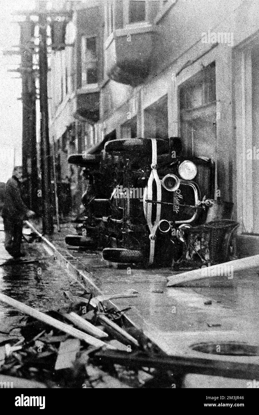 Evidence of the terrific force of the wind in North-East First Street, Miami, showing a large motor car blown onto its side (the car is possibly a Stutz).     Date: October 2nd 1926 Stock Photo