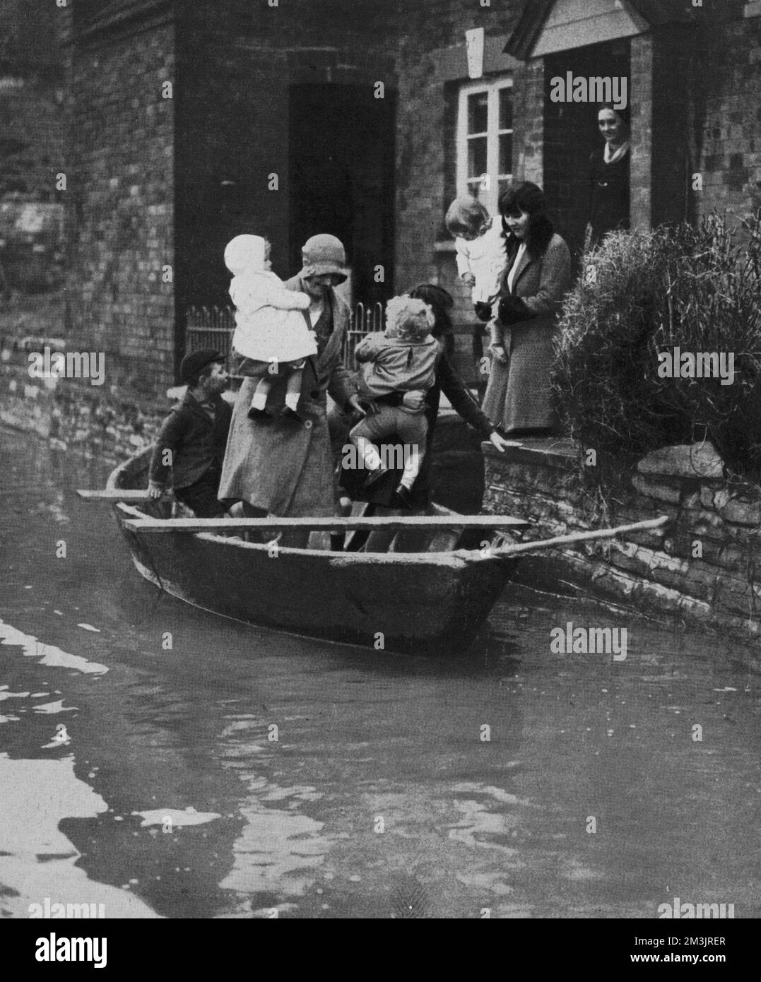 Athelney in Somerset, devastated by floods in 1930 showing the only method of travel around the area - in Venetian style, by boat. Despite the use of sand bags and a temporary wall the river Tone burst its banks and caused much destruction.  1930 Stock Photo