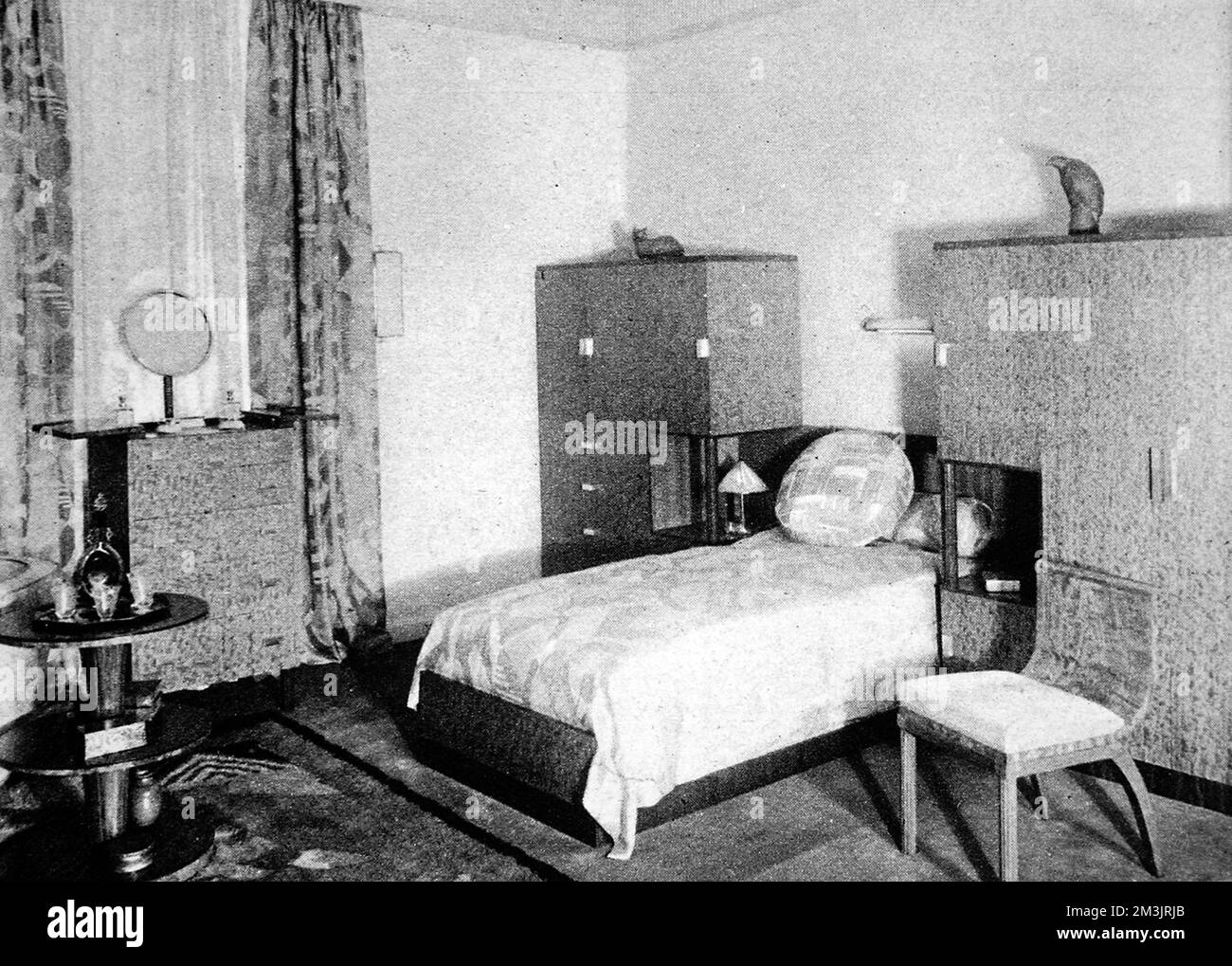 A man's bedroom; masculine straight lines with furniture of mahogany and lubinga. The new British furniture, a complete home in the modern manner. An exhibition at Waring and Gillow, the famous furniture house on Oxford Street.     Date: 1928 Stock Photo