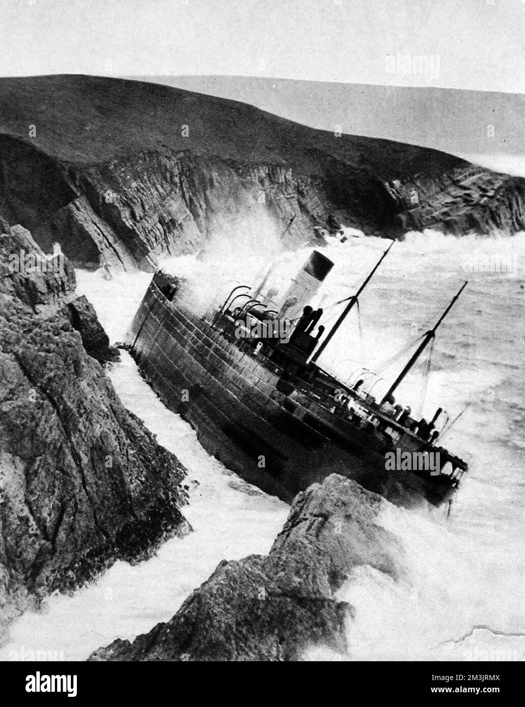 The wreck of the Herefordshire, seen here on the Cardigan coast. The old liner broke away from the tugs in stormy conditions, endangering her four crew. The Herefordshire was on her to the Clyde, the crew managed to scramble ashore and were discovered by the Gwbert life-saving crew.     Date: 1934 Stock Photo