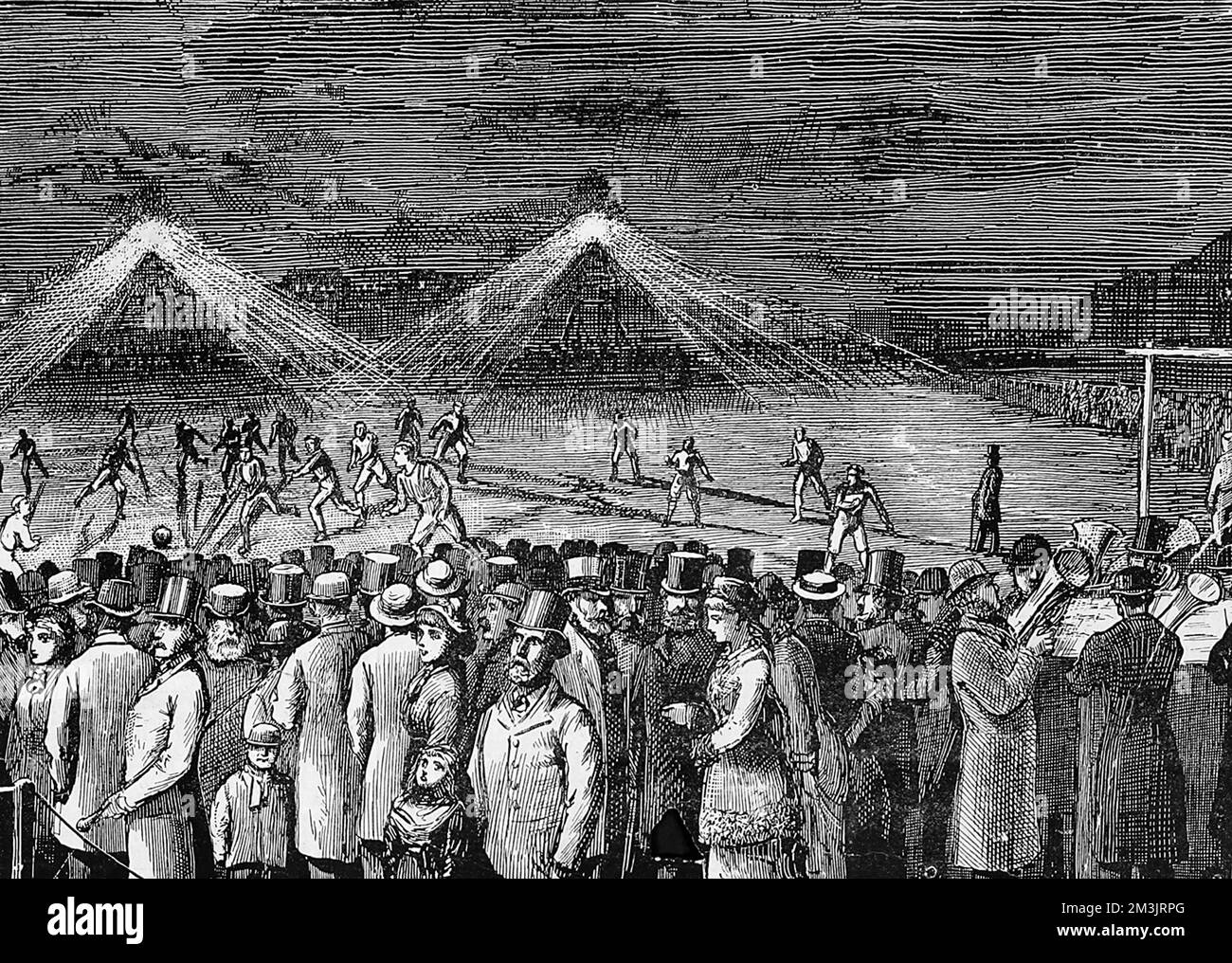 Spectators and players at a football match at Kennington Oval between the Wanderers and the Clapham Rovers illuminated by the new lighting system, which on this occasion was reported to be unsatisfactory due to the positioning of the lights. As illustrated in the sketch, the light caused shifting shadows and was confusing to the players. Stock Photo