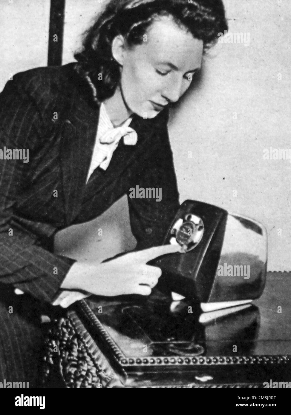 Woman demonstrating an electric toaster with adjustable dial at the