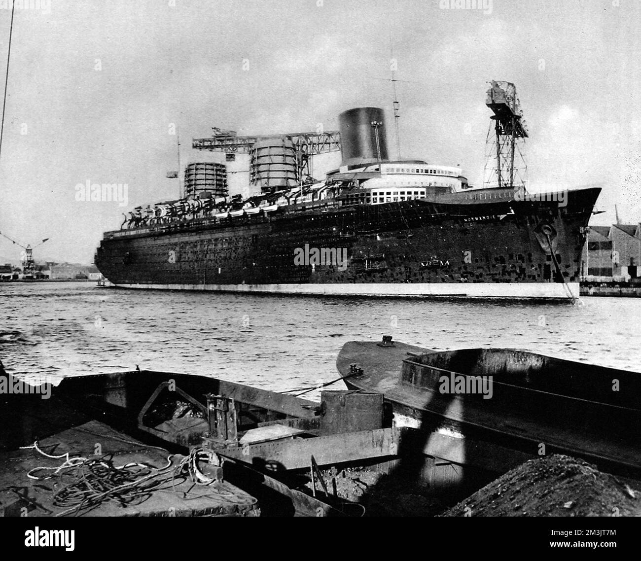 The liner 'Normandie' at St. Nazaire, February 1935. Launched in 1932, it took three years to fit her out. When she made her maiden voyage to New York in June 1935, she captured the Blue Riband quite easily, with a crossing of 4 days and three hours. Stock Photo