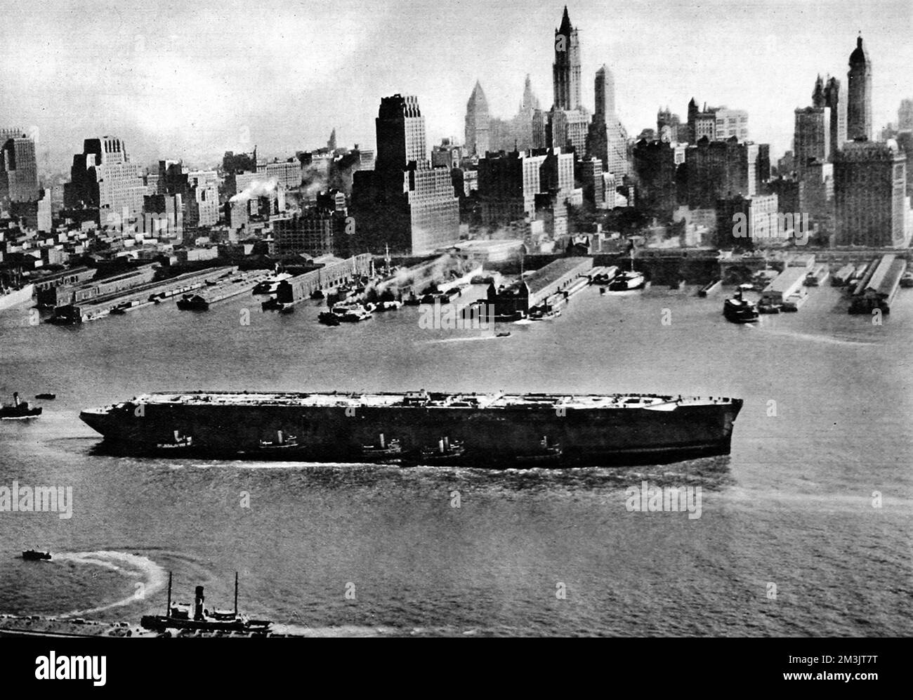 The 'Normandie' in New York Harbour, November 1943. The 'Normandie' had just been refloated and was being towed to dry dock for repairs, after catching fire and capsizing in the harbour during 1942. She was renamed 'Lafayette' by the US government and was intended to be refitted for war service. The estimated cost of the refit was 24,500,000 dollars.     Date: 1943 Stock Photo