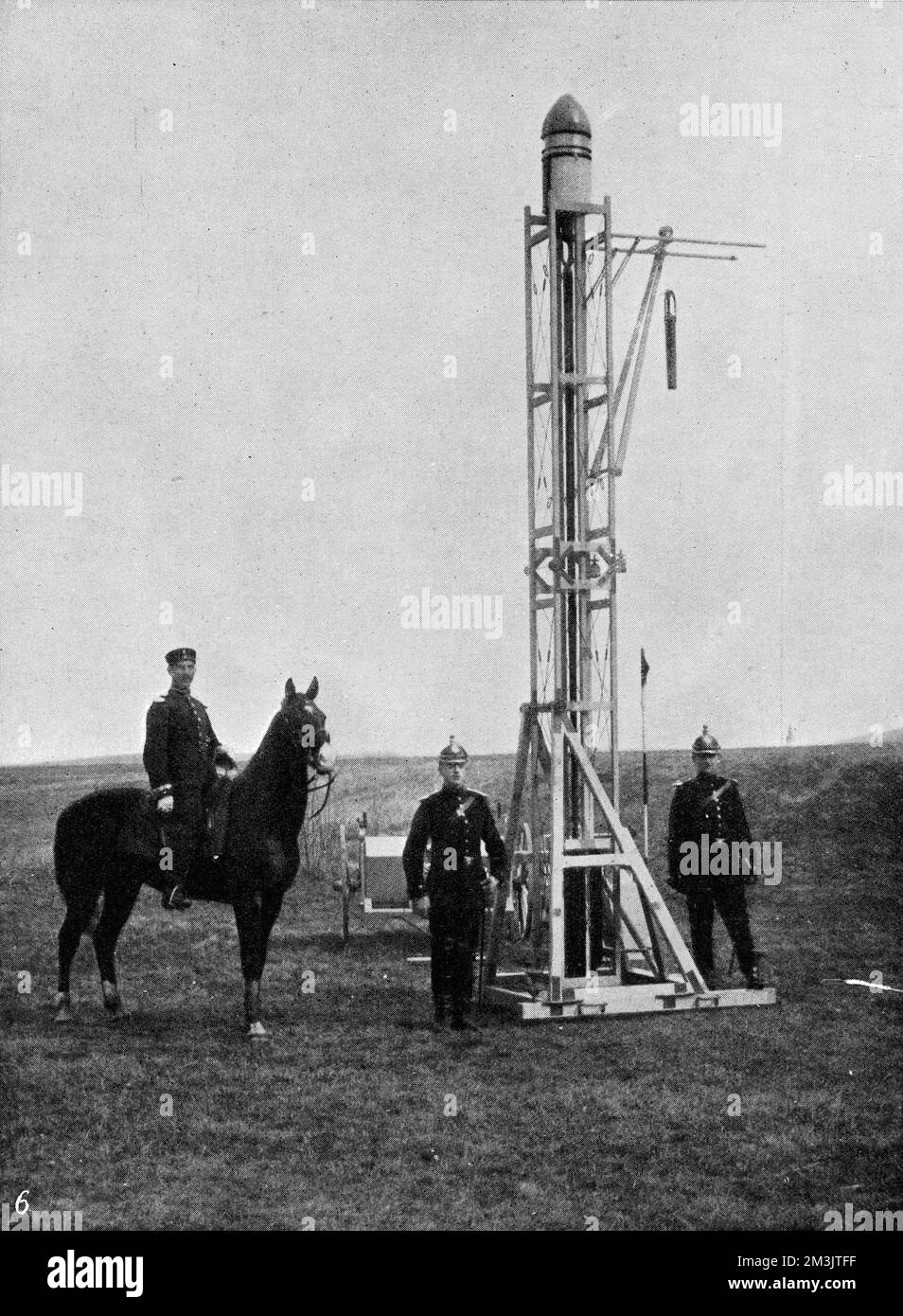 A rocket used to propel a camera to 2600 feet to capture an ariel image. The soldiers are pictured here ready to fire the rocket from its framework. When the camera reached its highest point there is a short pause before the parachute opens to position the camera and an exposure is made.  1912 Stock Photo