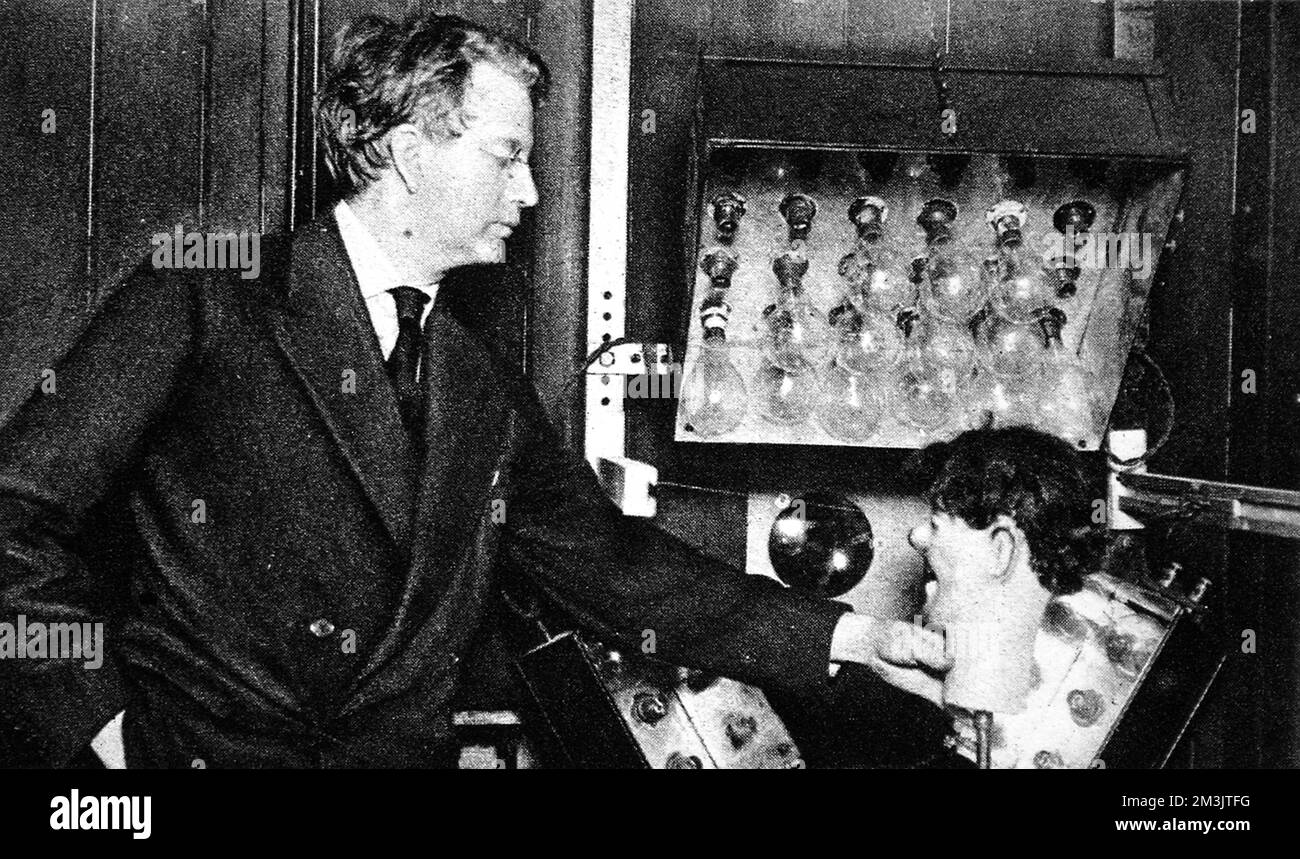 John Logie Baird's experiment with transatlantic television. He is pictured here with a ventriloquist's dummy head whose image was transmitted from London to New York by wireless.     Date: 1928 Stock Photo