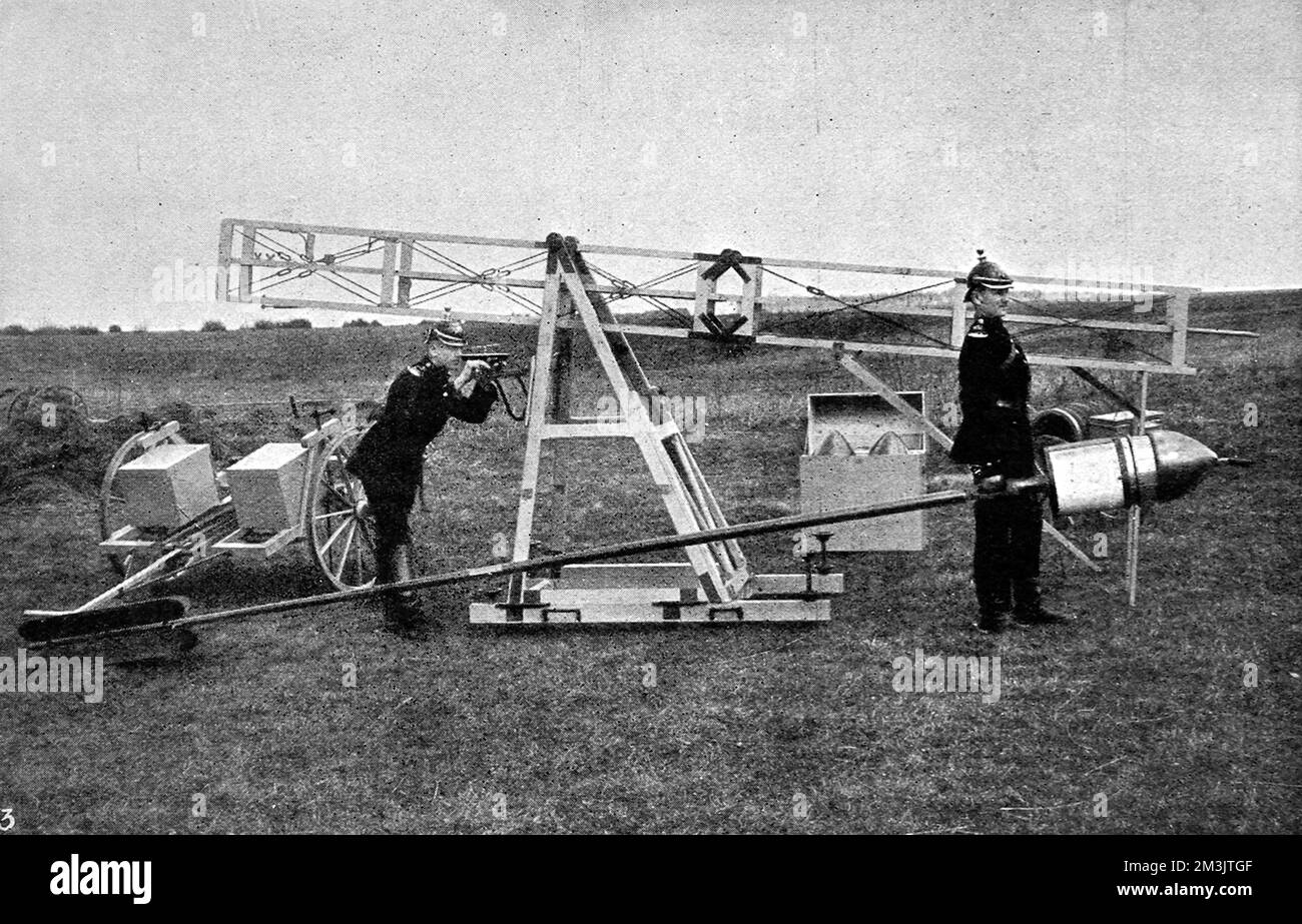 A rocket used to propel a camera to 2600 feet to capture an ariel image. Two soldiers are pictured here about to load the rocket into its framework before it is positioned ready to fire. When the camera reached its highest point there is a short pause before the parachute opens to position the camera and an exposure made.  1912 Stock Photo