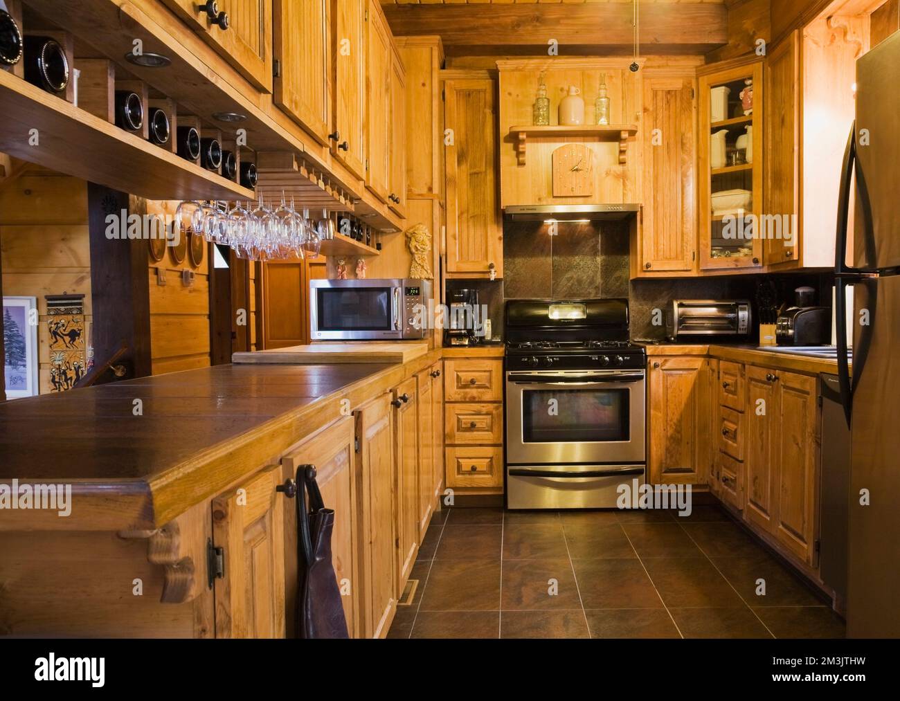 Wooden cabinets in kitchen with stainless steel appliances inside piece ...