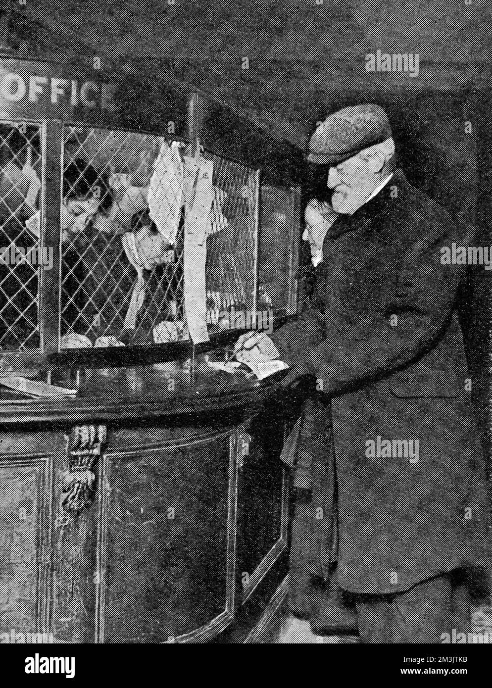 A typical scene on January 1st 1909 showing a man drawing his first pension at the post office. The Old Age Pension Act, introduced by David Lloyd George, allowed weekly payments to be made to all those who had qualified for the benefit.     Date: 1909 Stock Photo