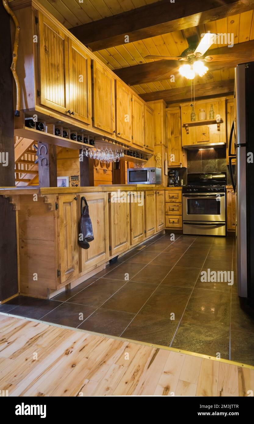 Wooden cabinets in kitchen with stainless steel appliances inside piece ...