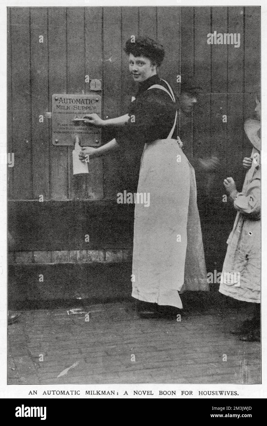 A novel way of housewives to obtain their milk. In various parts of London daires had a penny-in-the-slot machines where owners of the dairy could be shut and the customer could come and help themselves from a hole in the wall. Stock Photo