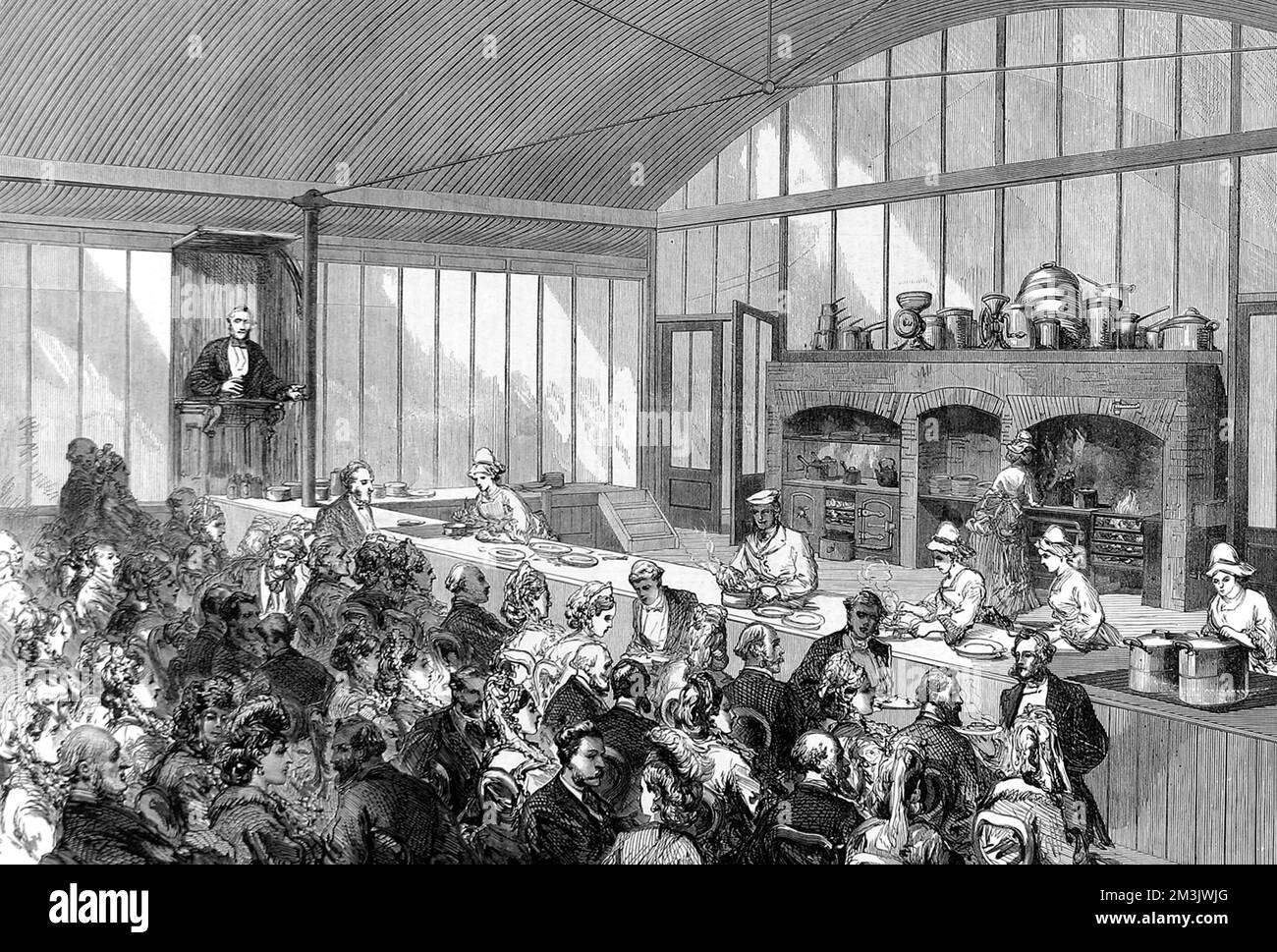 Lecture on cookery attended by a well-heeled crowd at the London International Exhibition of 1873. The short lectures, by Mr Buckmaster, accompanied demonstrations of the best methods of cooking different kinds of food. Guests could, on payment of a small fee, taste the prepared dishes. Queen Victoria attended one of Mr Buckmaster's lectures, and tasted an omelette fine herbes before inspecting German military cooking apparatus.  1873 Stock Photo