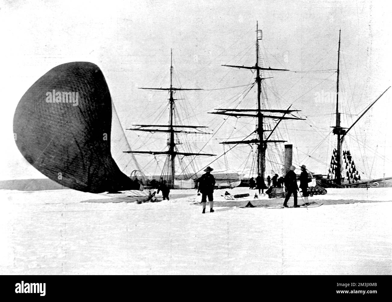 Photograph showing members of the National Antarctic Expedition of 1901-4 deflating an hydrogen balloon, with the Polar Research Ship 'Discovery' in the background, Antarctic, 4th February 1902.  This was the end of the very first balloon flight, to a height of 750 feet, undertaken in the Antarctic.     Date: 1903 Stock Photo