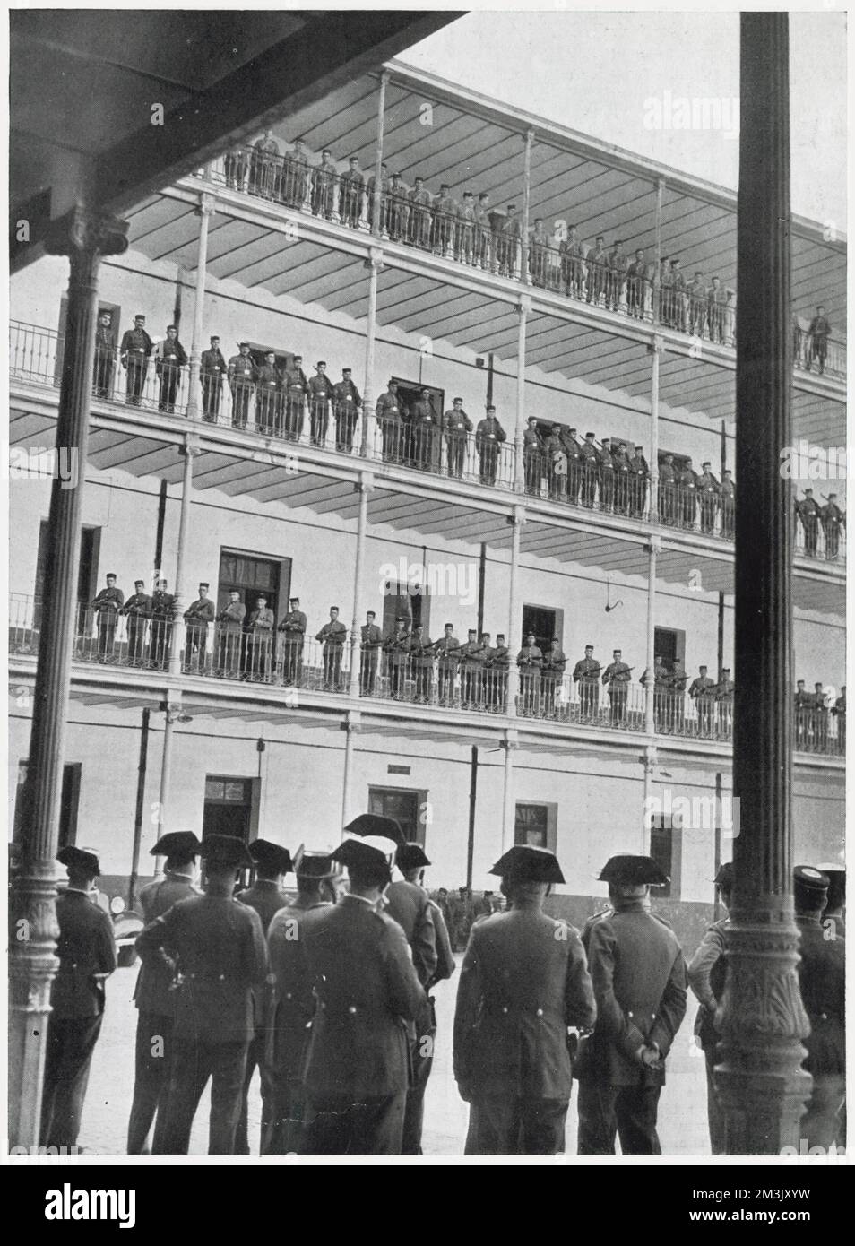 A Civil Guard Parade on a tiered building at their barracks, Spain, 1936. This was deemed a necessary alternative to drilling on the middle of the parade ground, under the burning sun of a summer's day.  The Civil Guard were a cross between a military unit and a police force, who worked to maintain peace and order in Spain in both times of war and peace. The Civil Guard took an active role in the Spanish Civil War, with guardsmen serving both the Republicans and the Nationalists. Stock Photo