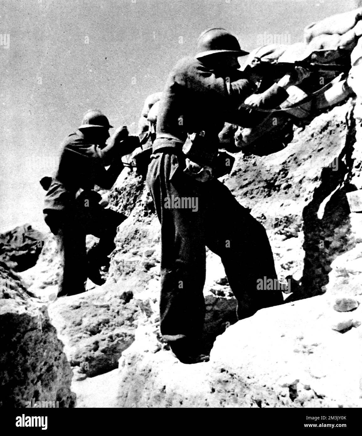 Photograph showing two soldiers of the Abraham Lincoln Battalion firing at Nationalist positions on the Morata Front, during the Spanish Civil War, 1937.  The men are pictured firing their rifles from a well sand-bagged trench.     The Abraham Lincoln Battalion was part of the International Brigade, a volunteer force which supported the Republican Government during the Spanish Civil War.  Volunteers came from all over Europe and North America; the Abraham Lincoln Battalion had men from Cuba, Mexico, the Philippines, Canada and the USA.     Date: 1937 Stock Photo