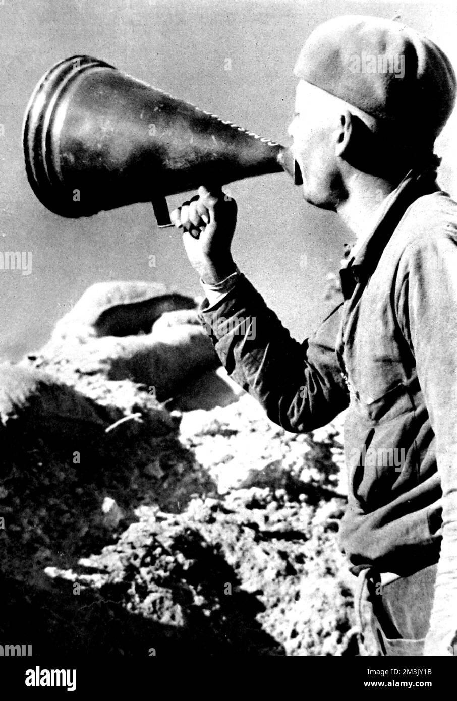 Photograph showing a Cuban soldier of the Abraham Lincoln Battalion, International Brigade, using a megaphone to implore Nationalist troops to join the Republican cause, 1937.      The International Brigade was a volunteer force which supported the Republican Government during the Spanish Civil War.  Volunteers came from all over Europe and North America; the Abraham Lincoln Battalion had men from Cuba, Mexico, the Philippines, Canada and the USA.     Date: 1937 Stock Photo