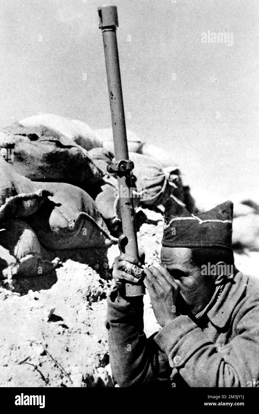 Soldier from the Philippine Islands serving in the Abraham Lincoln Battalion of the International Brigade, during the Spanish Civil War. This soldier is shown using a periscope to view the landscape towards the enemy, Nationalist, positions.  The International Brigade was a volunteer force which supported the Republican Government during the Spanish Civil War. Volunteers came from all over Europe and North America; the Abraham Lincoln Battalion had men from Cuba, Mexico, the Philippines, Canada and the USA.  1937 Stock Photo