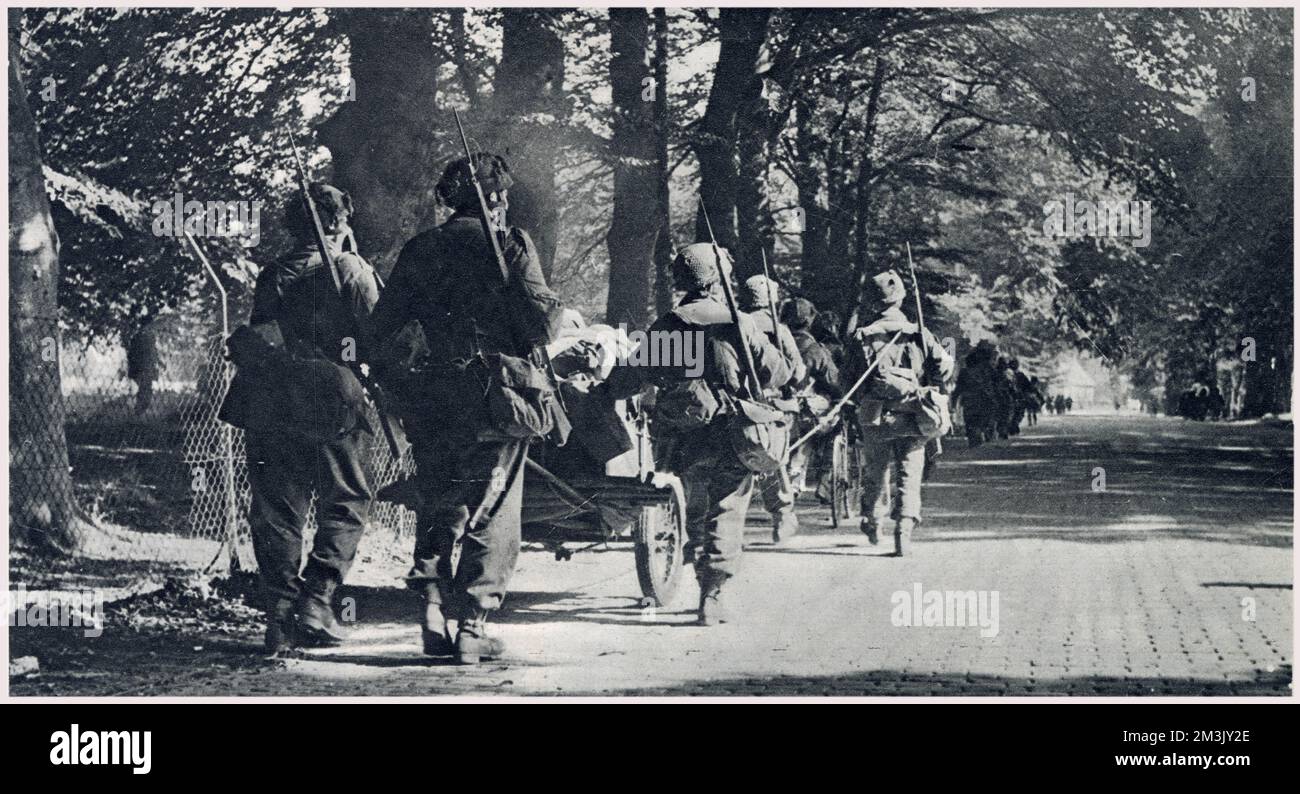 Soldiers of the British First Airborne Division marching into Arnhem with their guns and equipment, after landing outside the town, September 1944.  On 17th September 1944 Operation 'Market Garden' was put into action; a bold plan devised by Field-Marshal Montgomery to drop thousands of airborne troops into Holland to capture an invasion route into Germany. The British First Airborne, American 81st and 101st Divisions took part in the plan, which was ultimately unsuccessful. Stock Photo