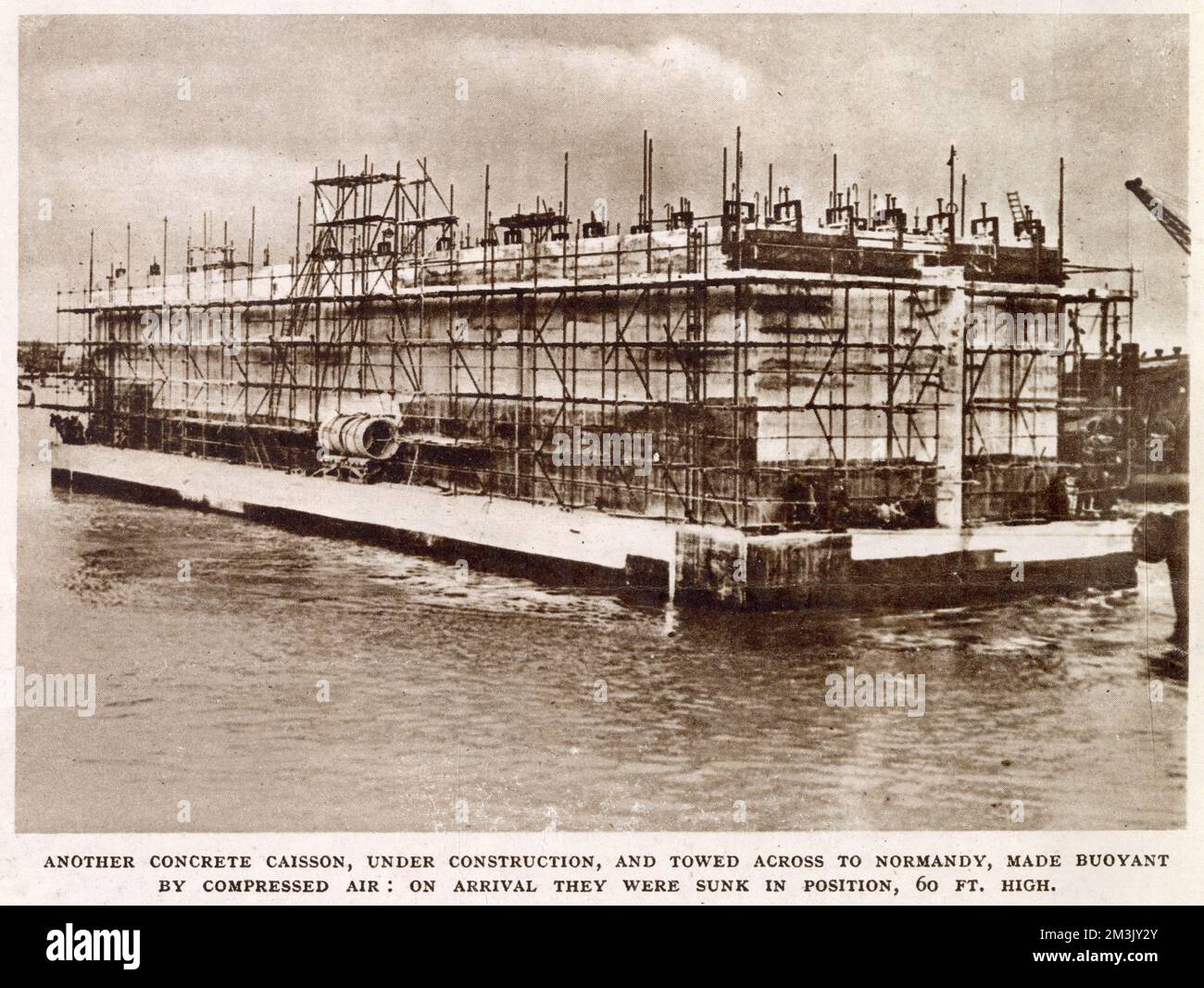 A steel and concrete 'Mulberry' caisson under construction on the South Coast of Britain during 1944.   When the Allied Armies invaded Normandy in June 1944, they required the use of a port to unload supplies quickly. The Allied commanders decided to take a pre-fabricated port, made of caissons such as the one pictured, and build it at Arromanches Beach. Stock Photo